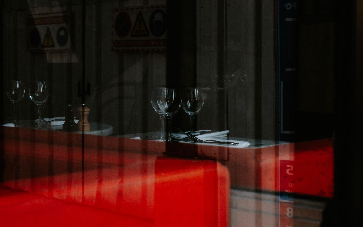 Wine glasses set out on a restaurant table, red wine ready to be served at room temperature.