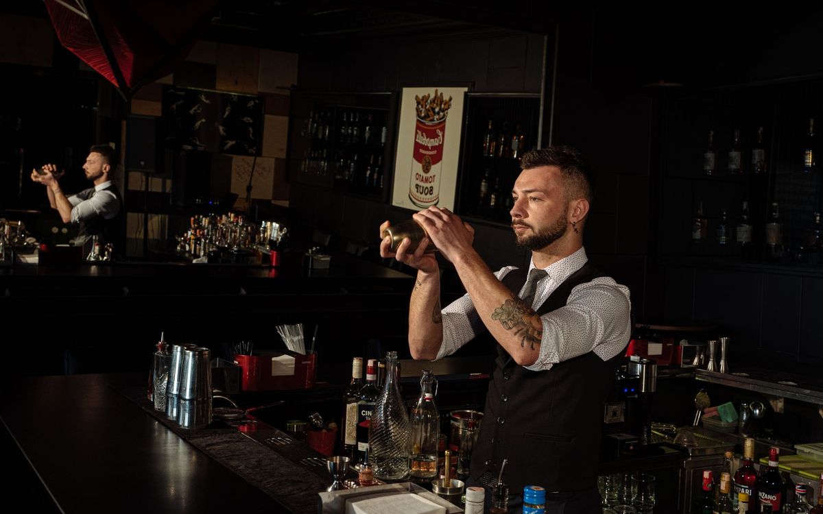 Bartender shaking a cocktail with ice in a shaker