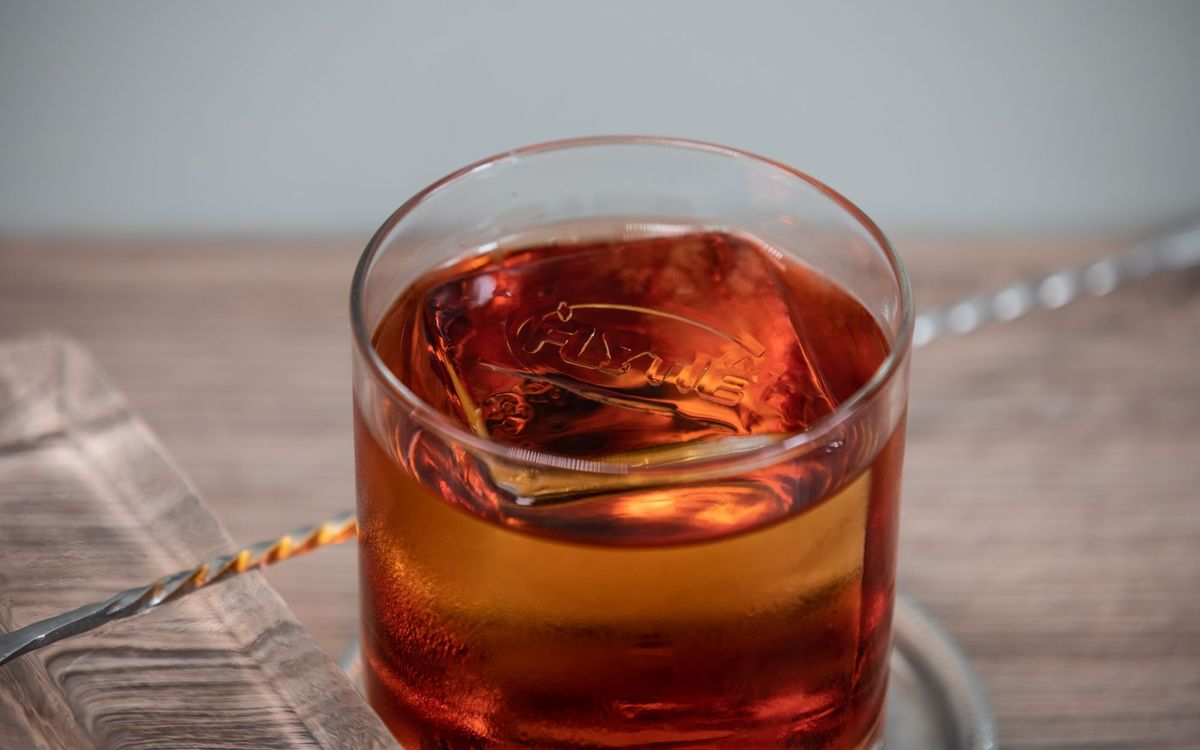 Whiskey on the rocks with large ice cubes in a rocks glass
