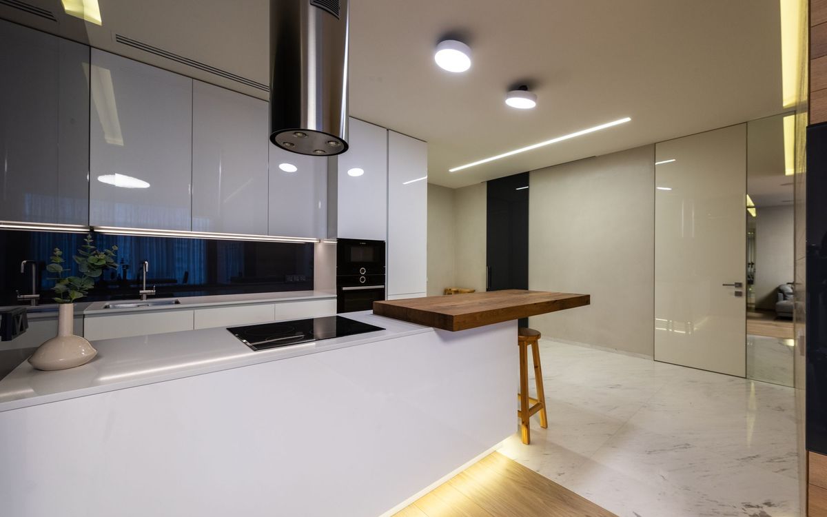Modern kitchen with glossy cabinets, a counter and built-in appliances
